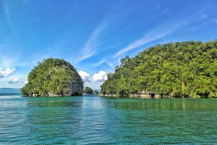 Zwei große, waldbedeckte Karstinseln, die aus dem ruhigen blauen Meer ragen.