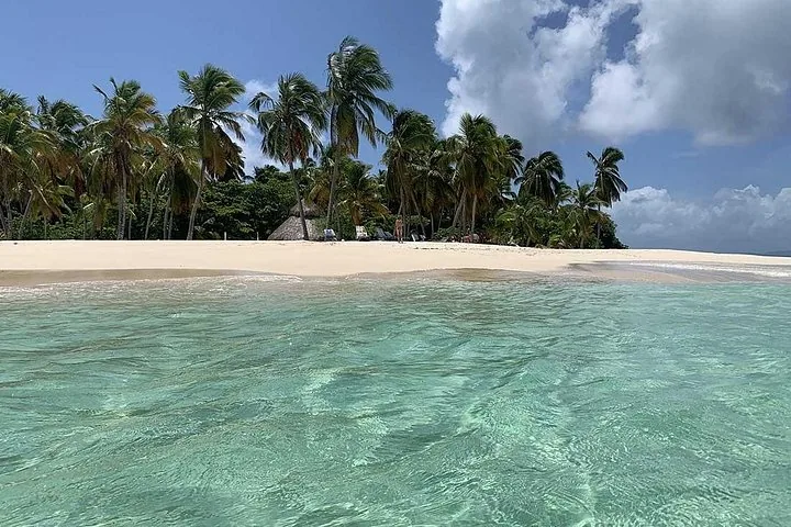 Ein wunderschöner Tropenstrand mit weißem Sand, klarem türkisfarbenem Wasser und Palmen.